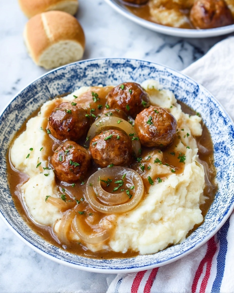 A white bowl with blue patterns holds a dish with three layers: the bottom layer is creamy mashed potatoes in a soft off-white color with smooth texture, topped by a rich brown gravy with visible slices of translucent cooked onions, and finished with round brown meatballs sprinkled with tiny green herbs. Around the bowl, there are light brown bread rolls placed on a white marbled surface with a white cloth that has blue and red stripes underneath the bowl. photo taken with an iphone --ar 4:5 --v 7