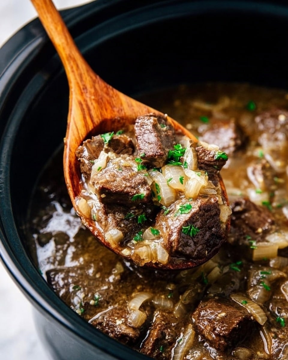 A close-up view of a black slow cooker filled with tender brown beef chunks mixed with light translucent cooked onions and small green herbs in a thick, glossy brown gravy, a dark wooden spoon lifting a portion from the pot, showing the juicy texture and steam rising from the hot meal, all set against a white marbled surface. photo taken with an iphone --ar 4:5 --v 7