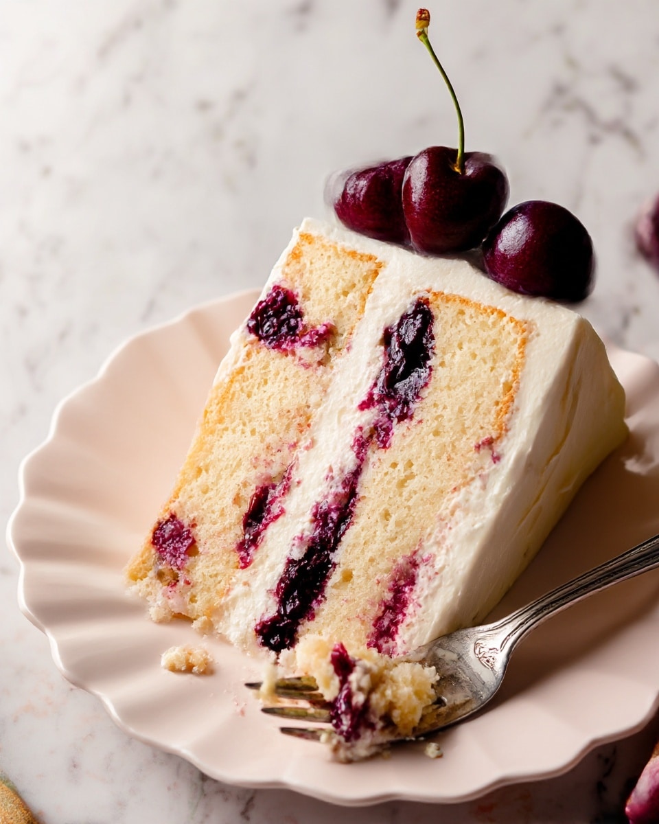 A slice of cake with three light yellow sponge layers separated by two layers of dark red and purple cherry filling mixed with creamy white frosting. The outside is covered with smooth white frosting, and two dark red cherries with stems sit on top at the back. The cake slice is on a white, scalloped-edge plate with a silver fork beside it that has bits of cake and filling. The background is a white marbled texture. photo taken with an iphone --ar 4:5 --v 7